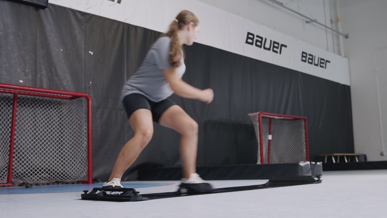 a girl sliding and lunging back and forth on a black slide platfor